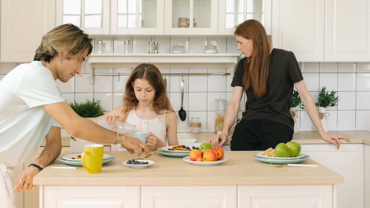 A family shares a healthy breakfast together in a modern kitchen setting.
