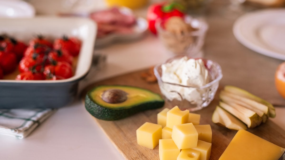 A delectable cheese platter with avocado, tomatoes, and cream cheese, perfect for sharing.